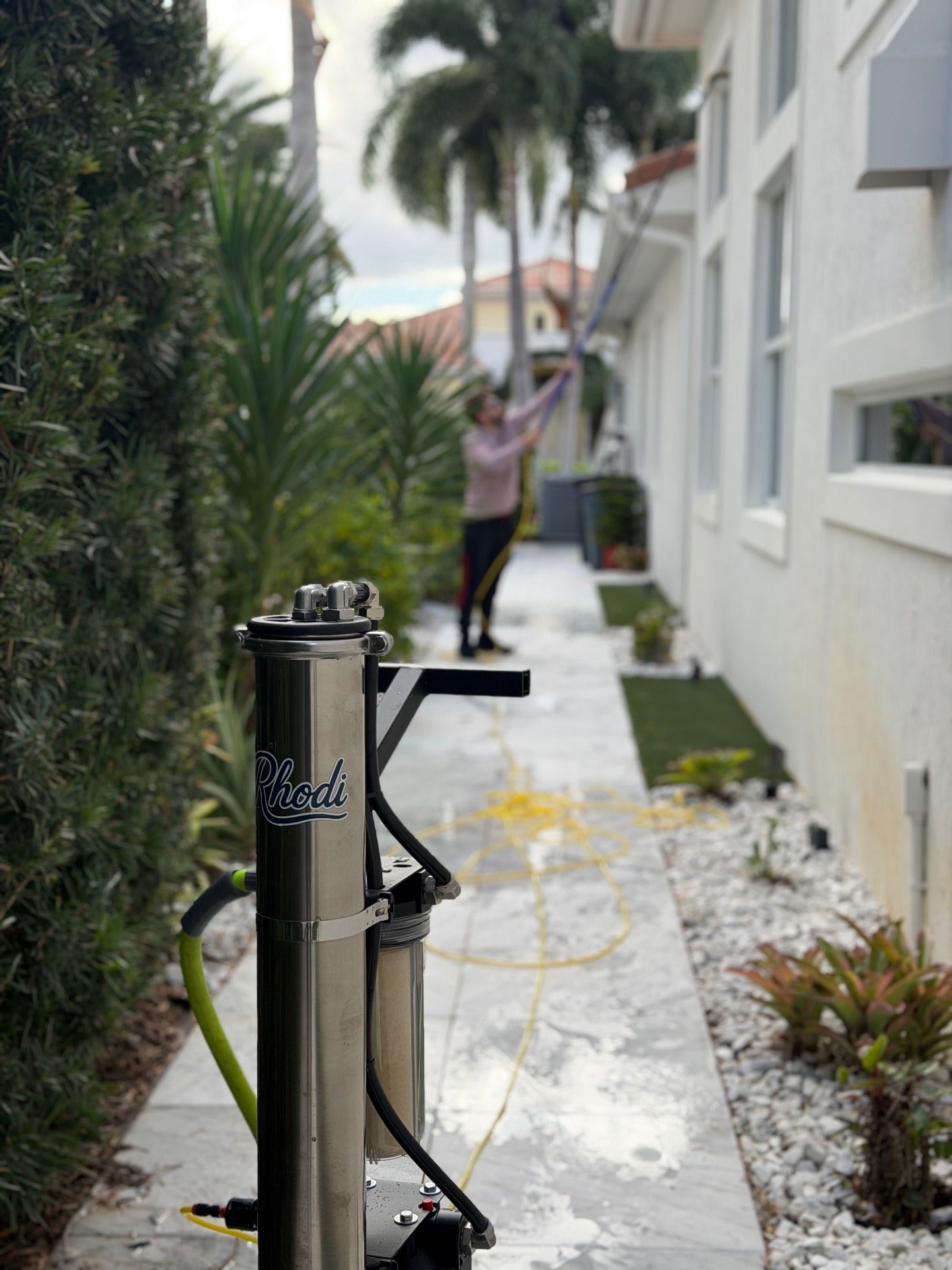 Hose reel on a sidewalk with a person in the background